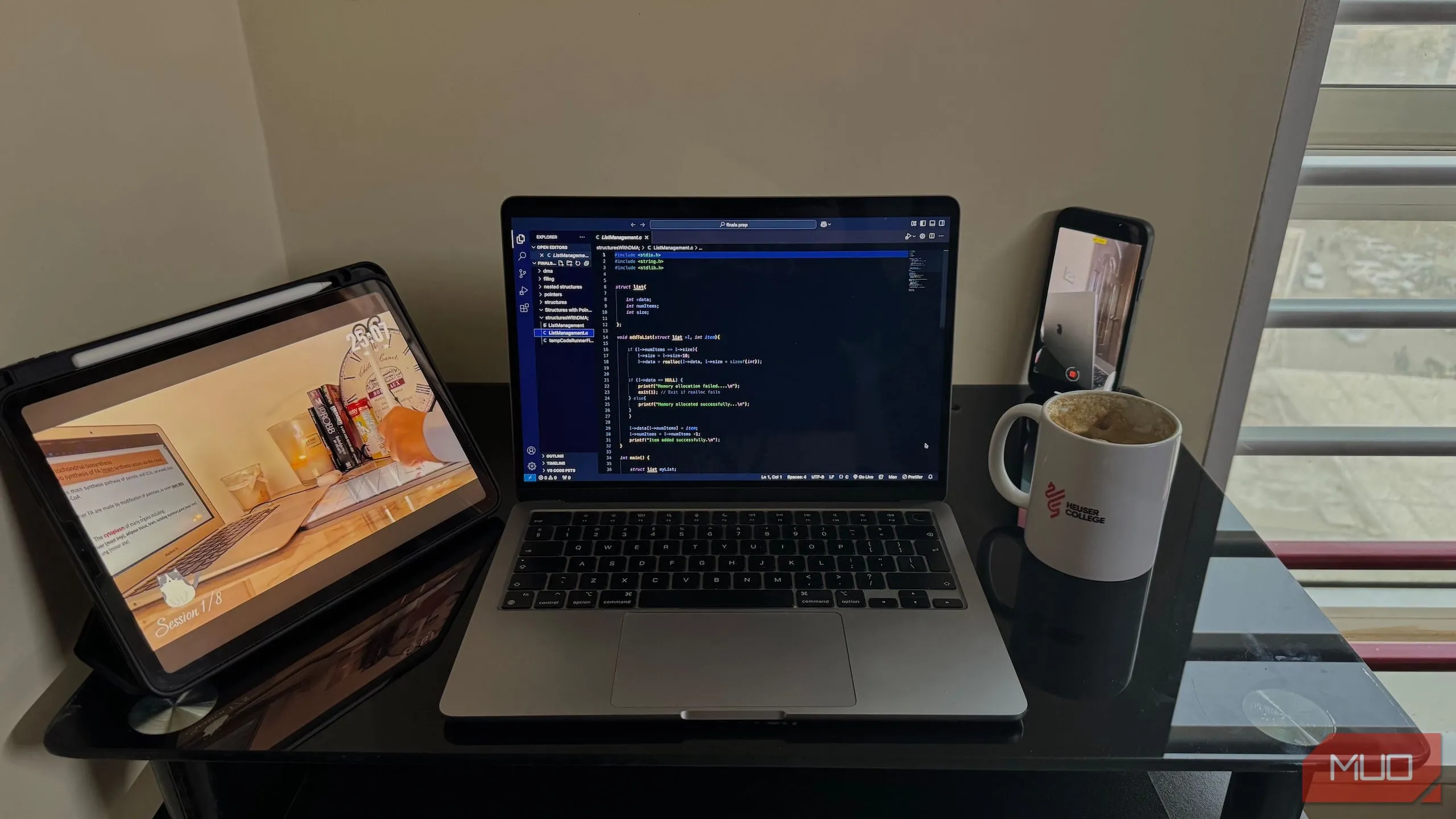 Bàn làm việc với MacBook, iPad và điện thoại đặt gọn gàng, sẵn sàng quay video time-lapse quá trình làm việc.