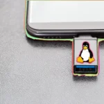 Biểu tượng Tux Linux trên USB cứu hộ cắm vào laptop, minh họa USB cứu hộ SystemRescue đa năng