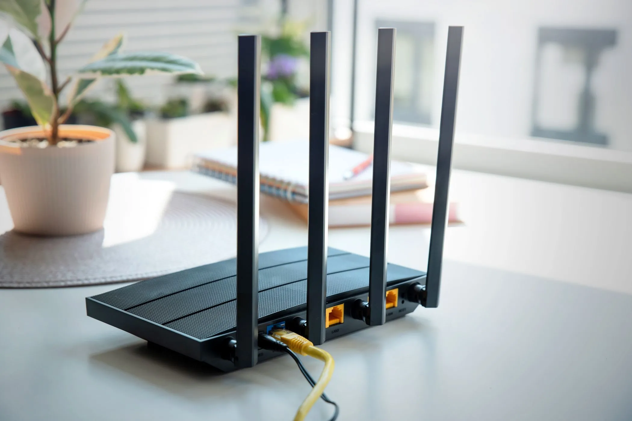 Bộ định tuyến Wi-Fi hiện đại với bốn ăng-ten trên bàn