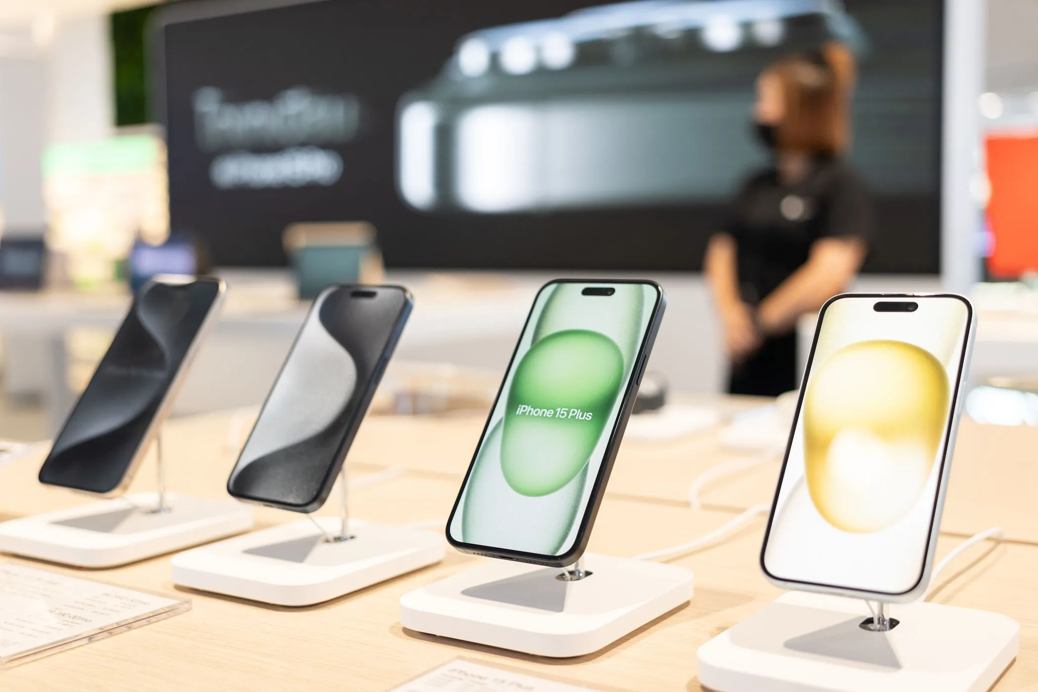 Các mẫu điện thoại iPhone 15 mới đang được trưng bày tại cửa hàng Apple, đối lập với việc kéo dài thời gian sử dụng iPhone cũ để giảm tác động môi trường.