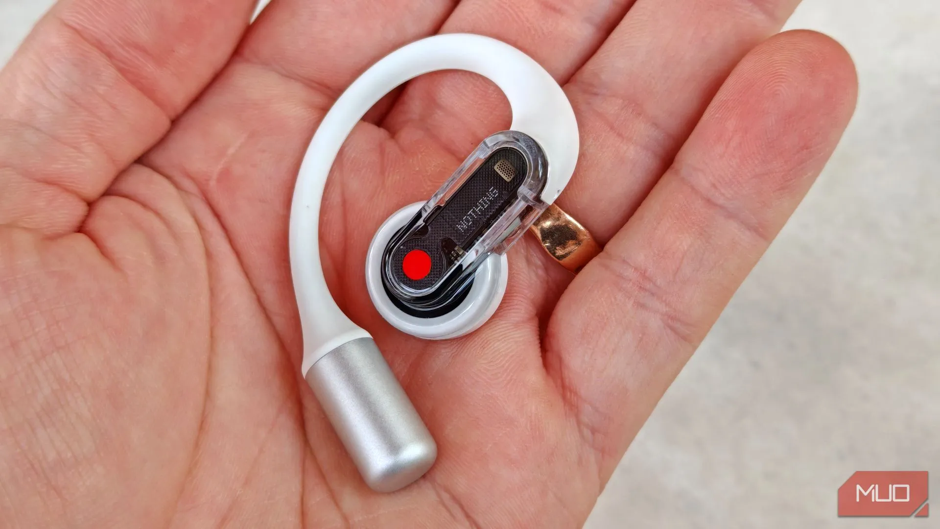 Cầm tai nghe Nothing Ear (open) bên phải trên tay, cho thấy thiết kế công thái học