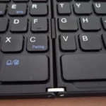 Cận cảnh bản lề trung tâm trên bàn phím gập Bluetooth, cho thấy thiết kế có thể ảnh hưởng đến bố cục phím.