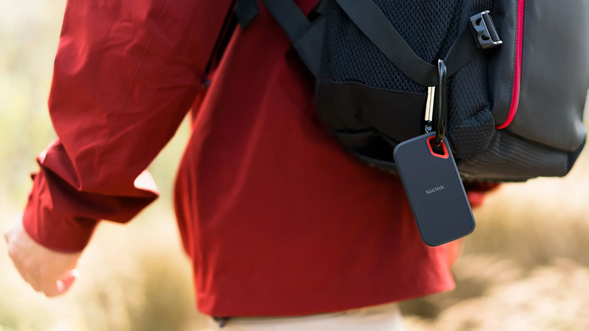 Chiếc SSD di động Sandisk Extreme Portable 8TB được gắn vào ba lô người dùng trong môi trường ngoài trời