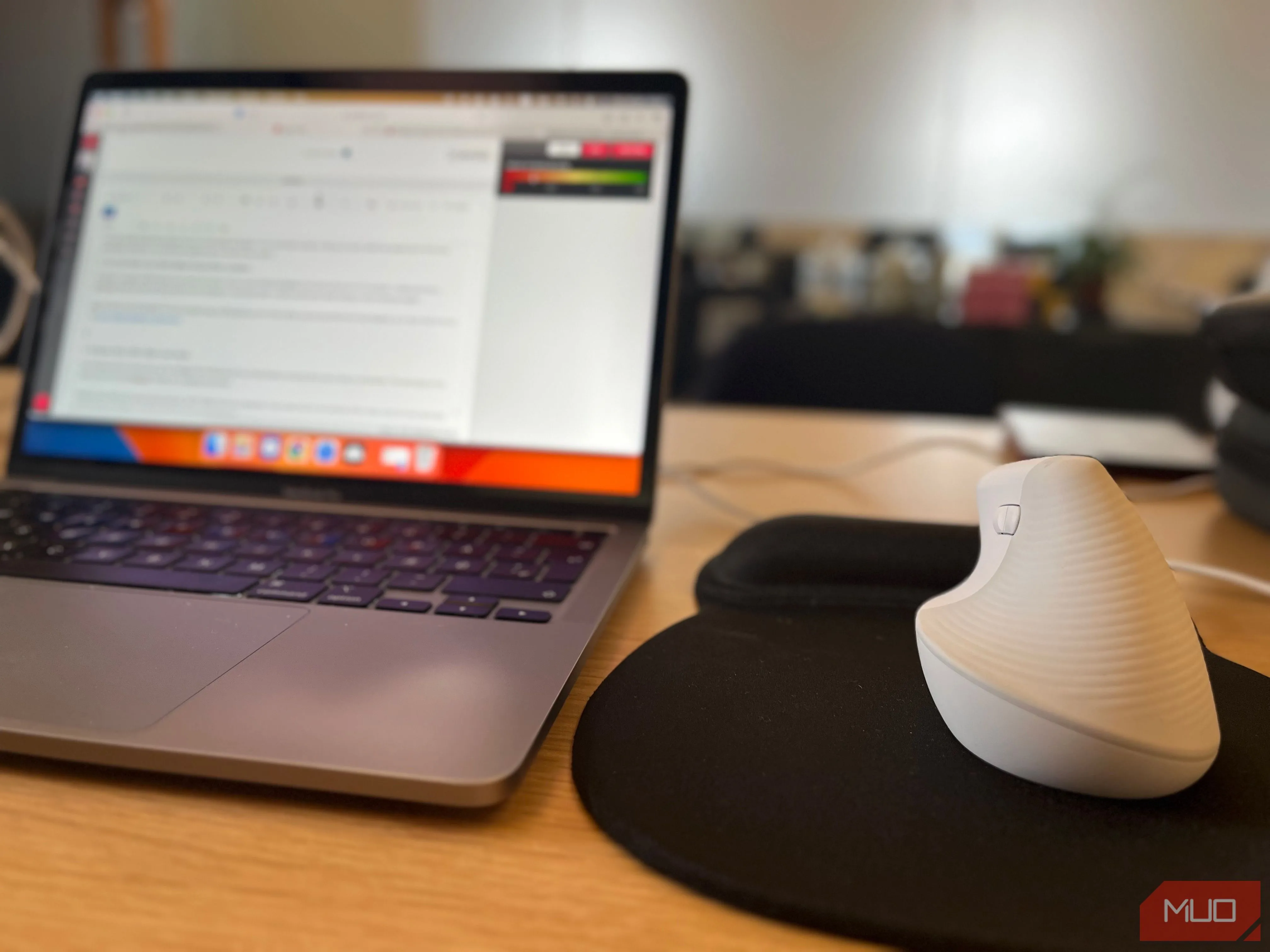 Chuột không dây và laptop trên bàn làm việc trong không gian coworking, thể hiện sự tiện lợi khi di chuyển và làm việc linh hoạt.