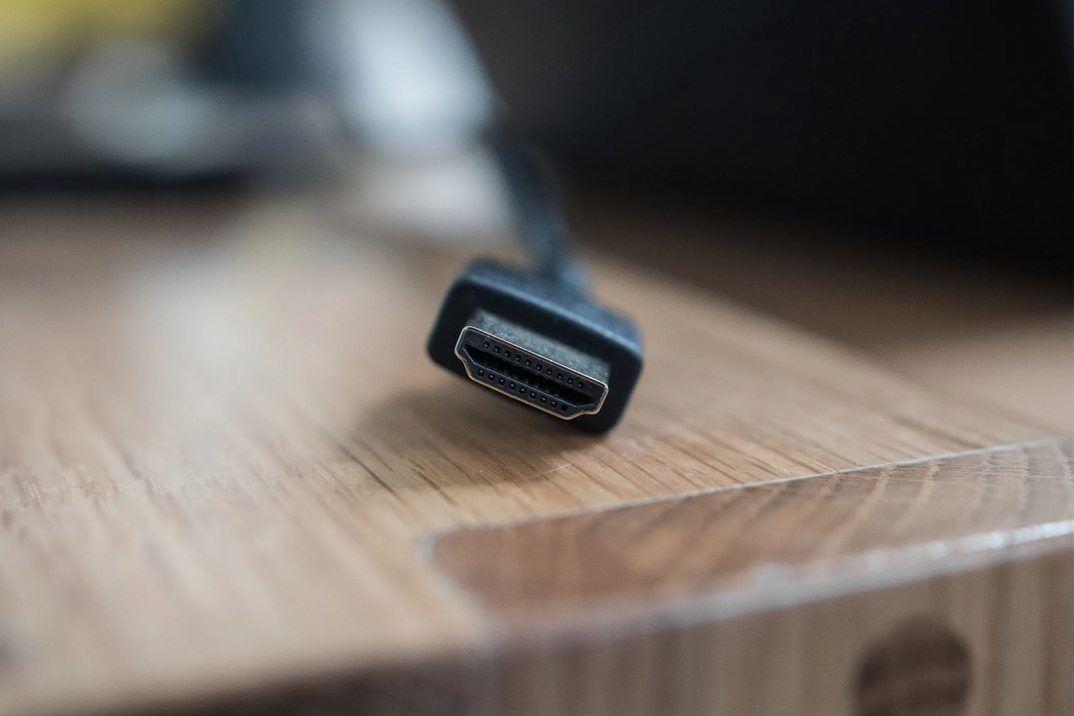Đầu nối cáp HDMI tiêu chuẩn đặt trên mặt bàn gỗ, minh họa cho cổng kết nối video