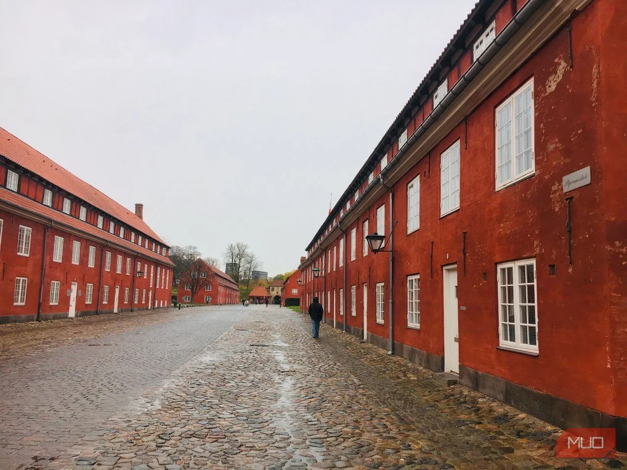 Dãy nhà lính màu đỏ nổi bật tại pháo đài Kastellet dưới bầu trời mờ sương, thể hiện kiến trúc quân sự và không gian lịch sử.