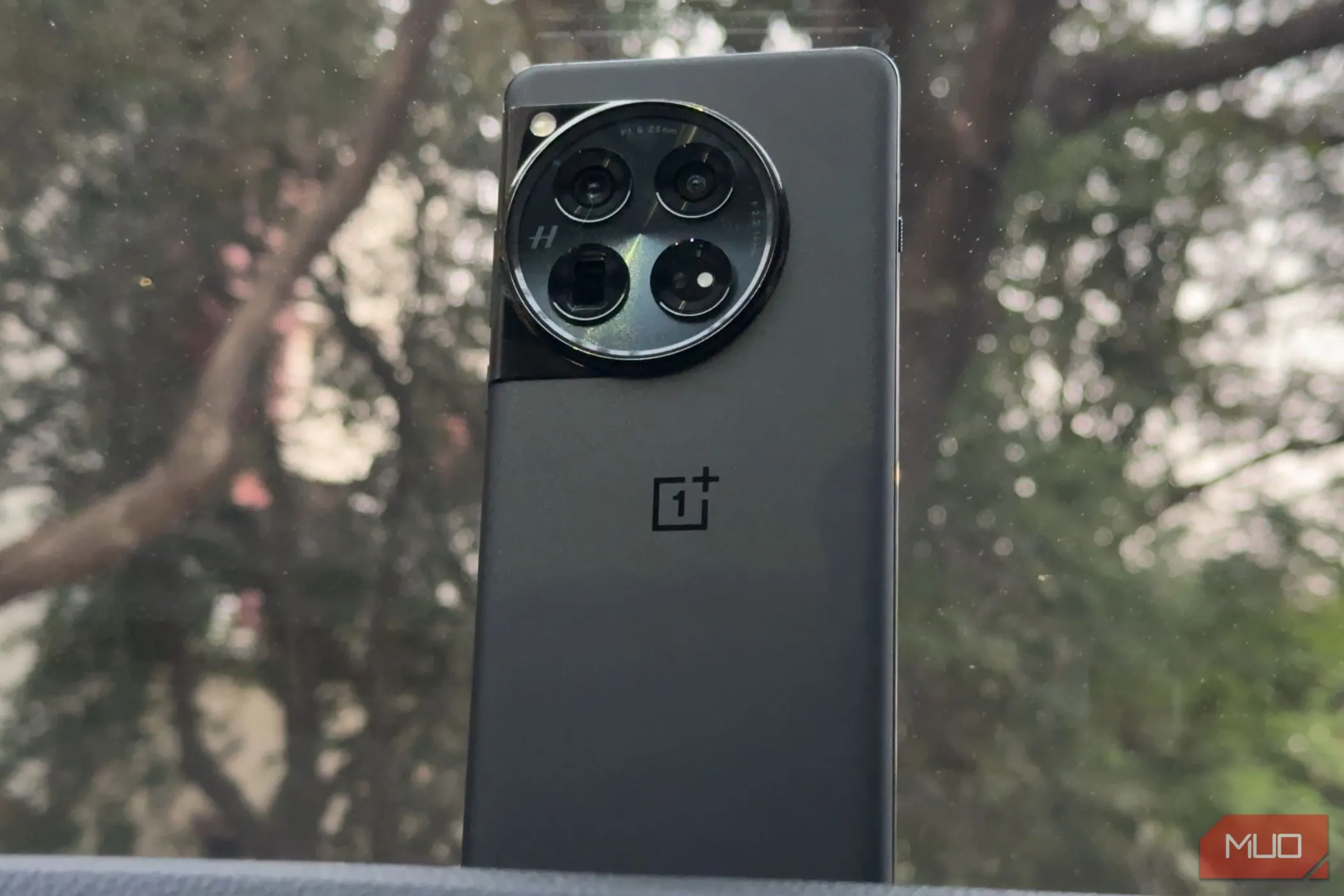 Điện thoại OnePlus 12 màu đen sang trọng đặt trên táp-lô ô tô