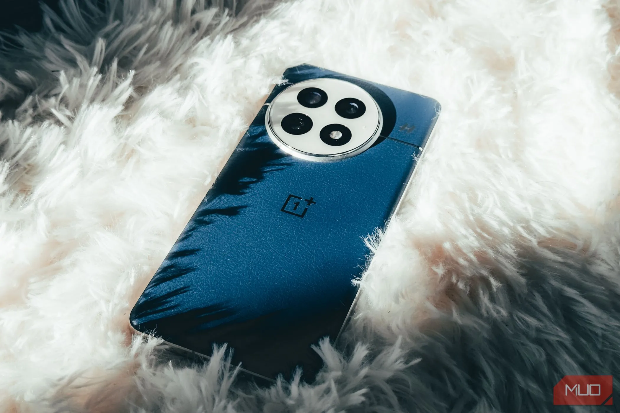 Điện thoại OnePlus 13 đặt trên thảm trắng, làm nổi bật thiết kế