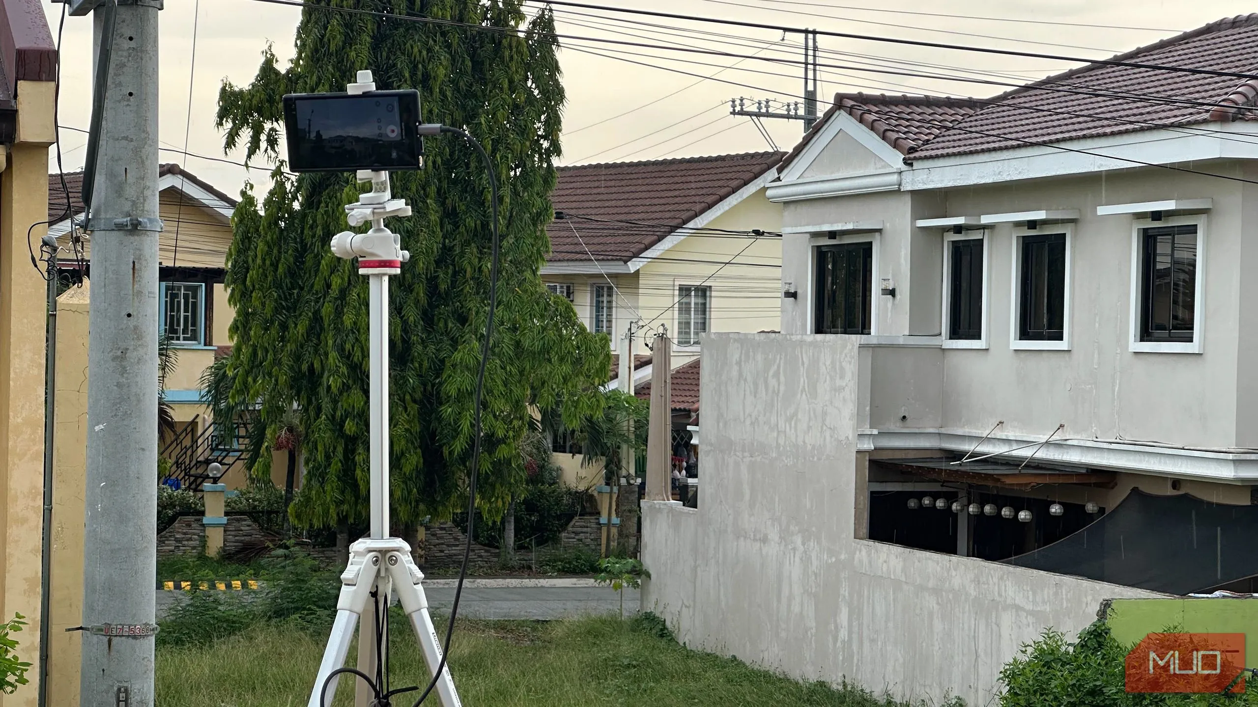 Điện thoại thông minh được đặt trên chân máy, đang quay video timelapse từ ban công một căn hộ với khung cảnh thành phố.