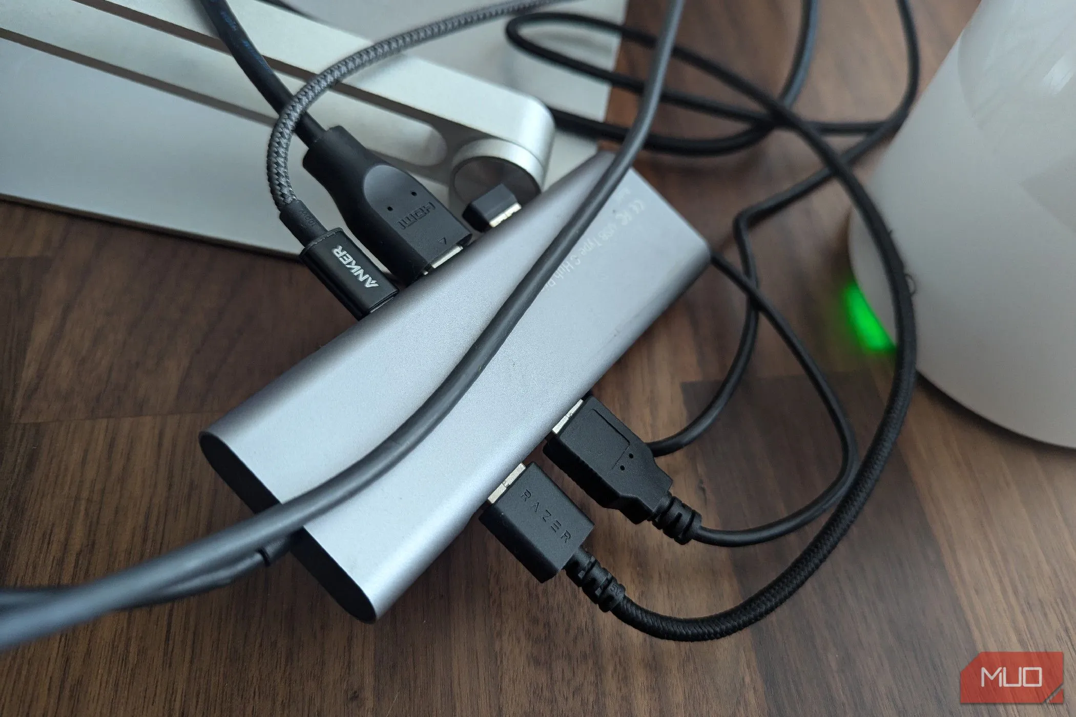 Dock USB-C thông thường với nhiều cáp kết nối, trông lộn xộn trên bàn làm việc, minh họa sự thiếu gọn gàng.