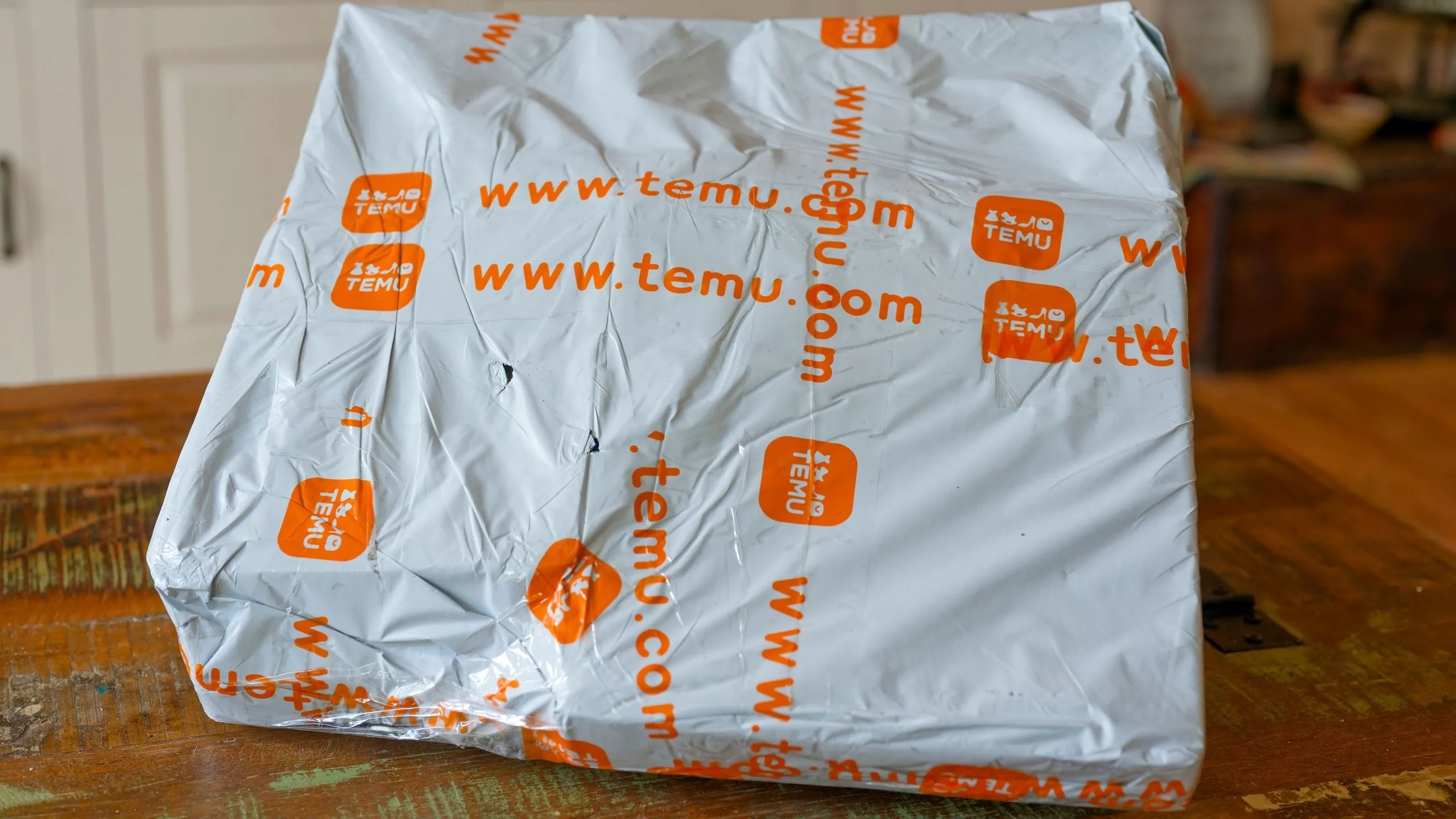 Gói hàng Temu trên bàn minh họa tác động của chính sách thuế quan mới