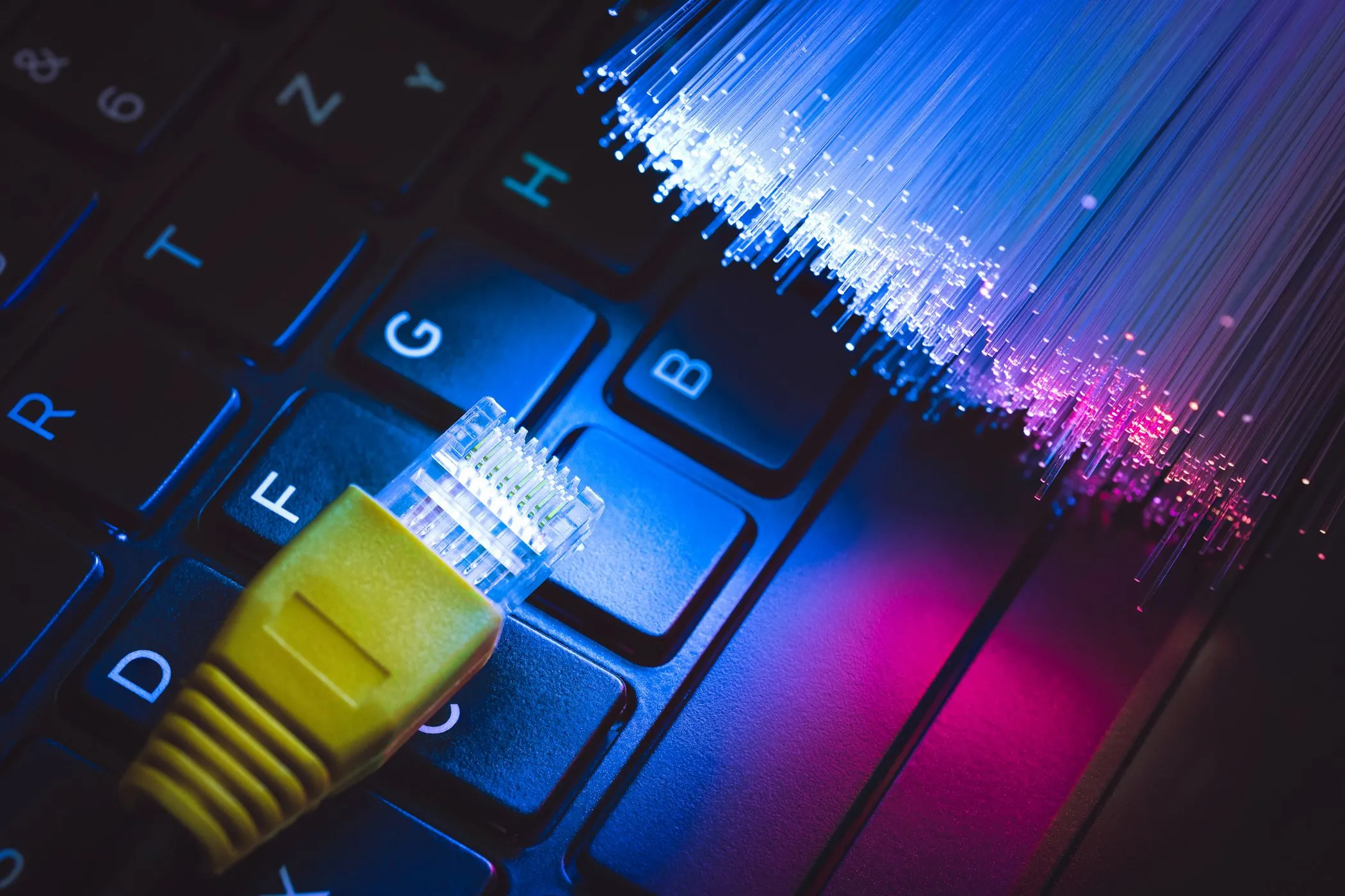 Hình ảnh cáp Ethernet được cắm vào máy tính xách tay với cáp quang ở gần