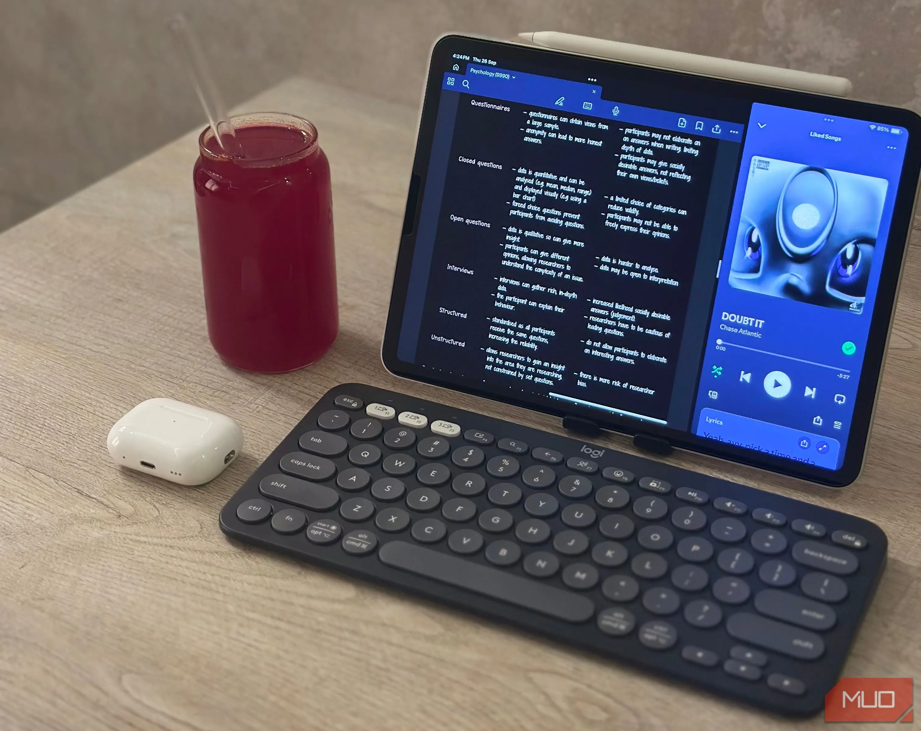 Hình ảnh iPad Air M1 cùng bàn phím Logitech Pebble Keys 2 K380s và tai nghe AirPods trên bàn làm việc, minh họa thiết lập làm việc gọn nhẹ với iPad.