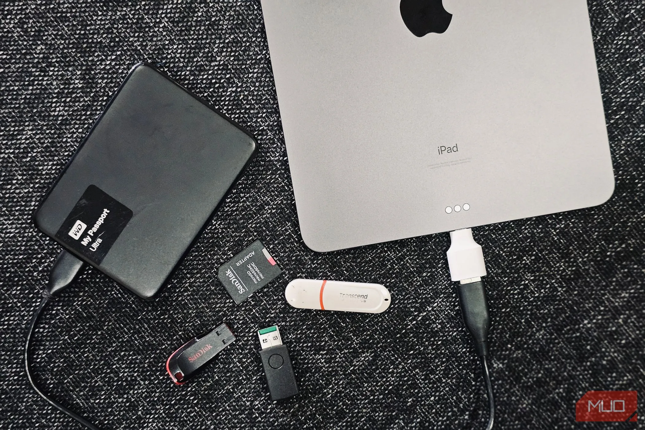 Hình ảnh minh họa các ổ cứng di động và iPad, tượng trưng cho việc sao lưu dữ liệu kép