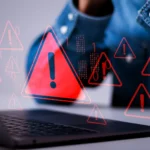 Hình ảnh rò rỉ dữ liệu trên màn hình laptop với biểu tượng cảnh báo đỏ, minh họa nguy cơ tấn công mạng khi sử dụng công cụ chuyển đổi file không an toàn.