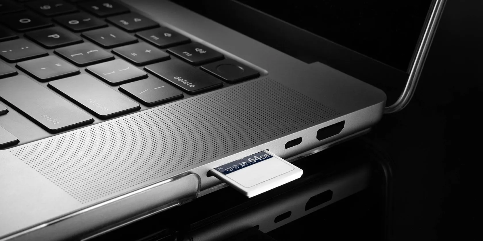 Hình ảnh thẻ nhớ SD đang được đưa vào khe cắm trên cạnh một chiếc laptop, tượng trưng cho tính năng bộ nhớ mở rộng