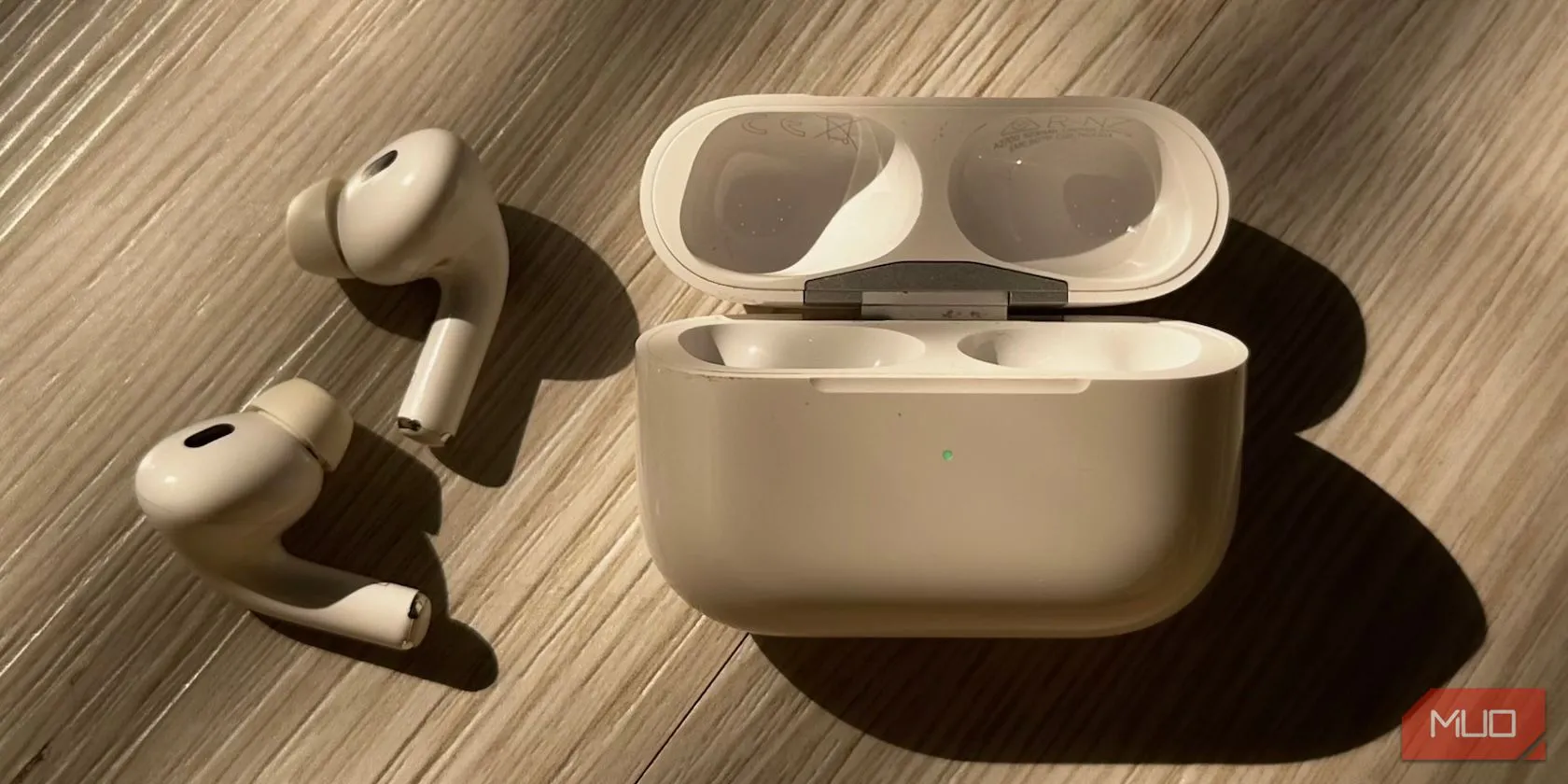 Hộp sạc AirPods với đèn trạng thái màu xanh lá, minh họa đặc điểm thiết kế chung của các hộp sạc hình chữ nhật.