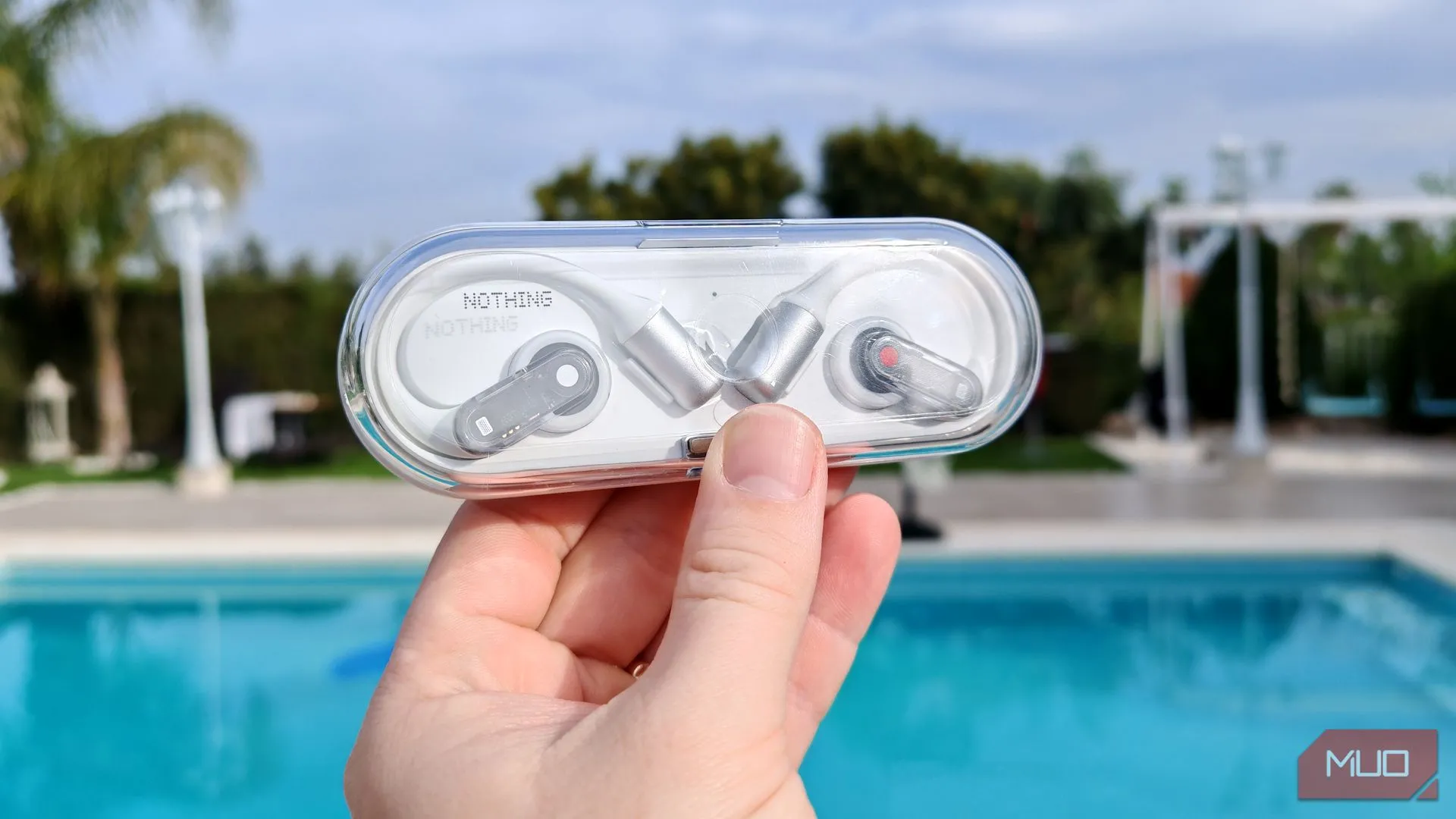 Hộp sạc Nothing Ear (open) trong suốt được cầm trên tay ở ngoài trời
