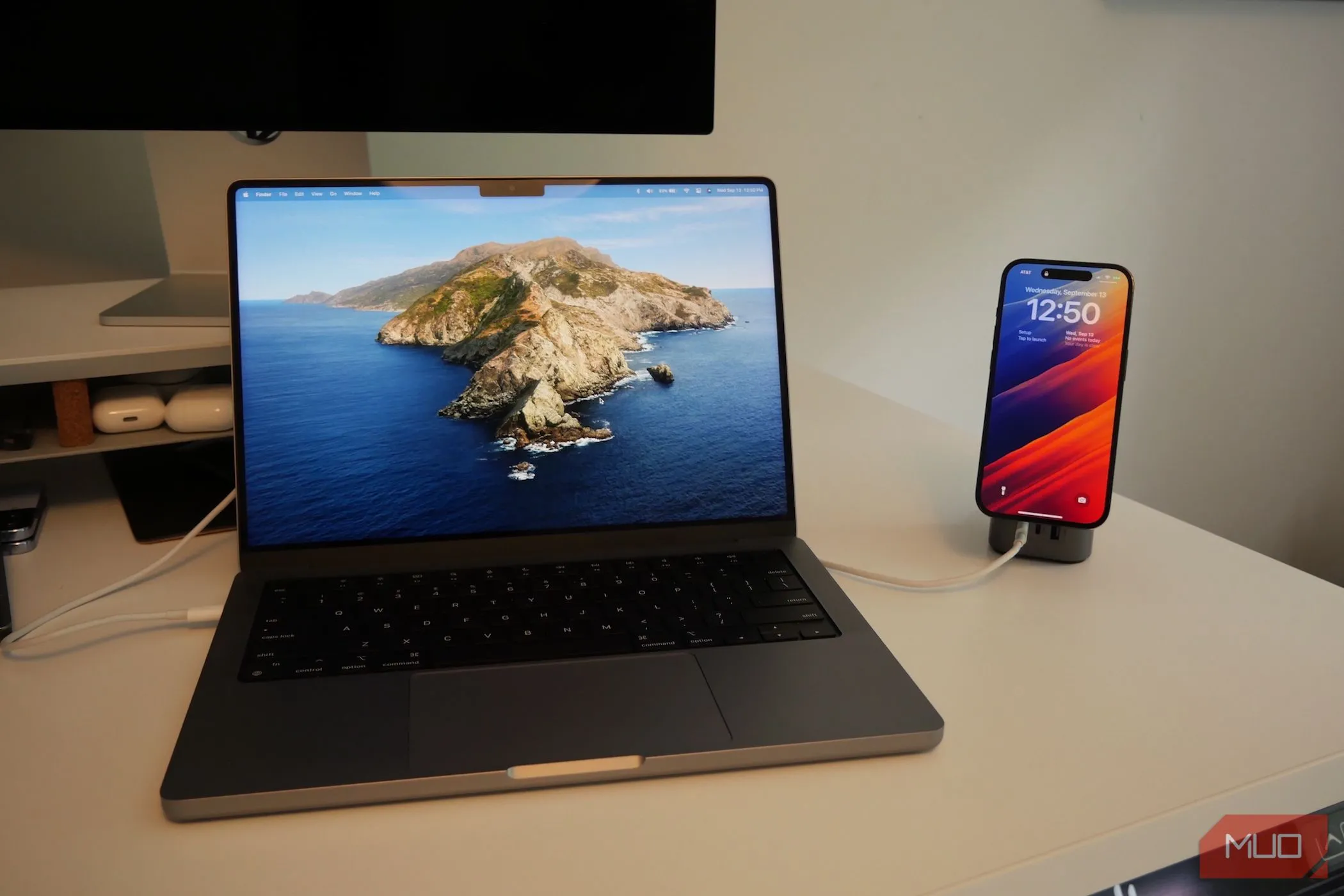 iPhone đang sạc cạnh MacBook Pro, tượng trưng cho việc sử dụng iPhone như một loa phụ