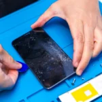 Kỹ thuật viên đang cẩn thận cạy mở smartphone để sửa chữa, minh họa quy trình bảo trì chuyên nghiệp