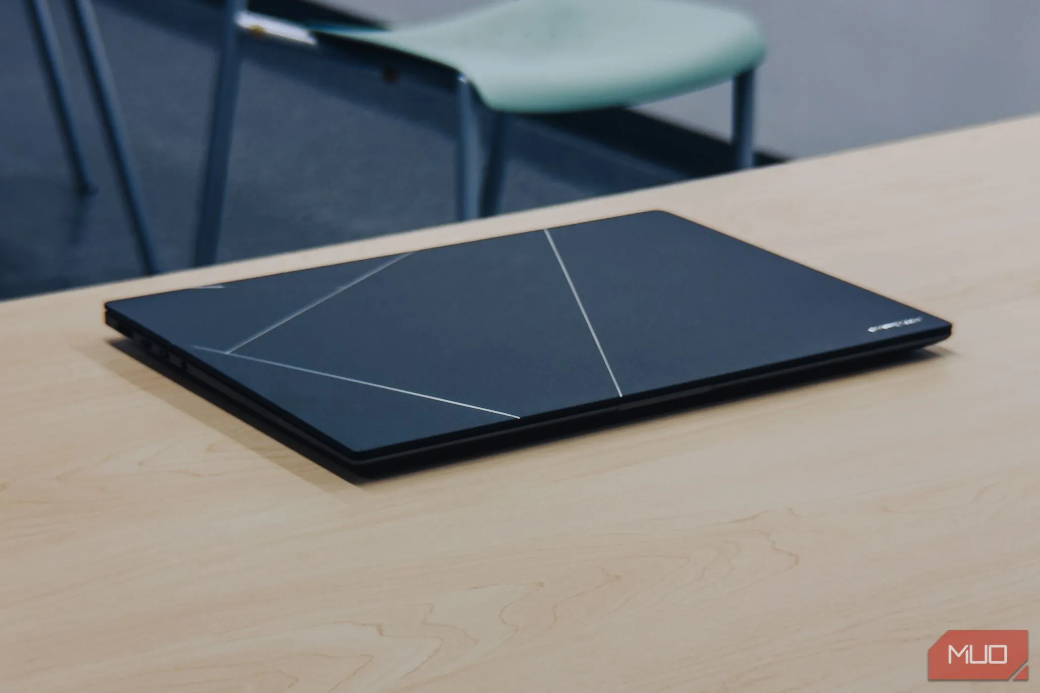 Laptop ASUS Zenbook S 16 OLED màu trắng gập lại trên bàn gỗ