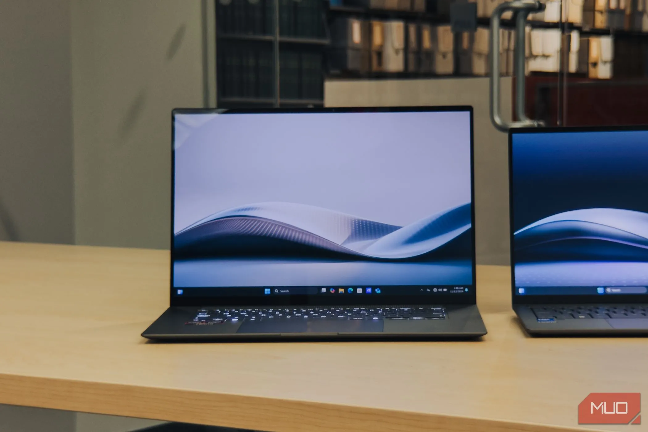 Laptop ASUS Zenbook S 16 OLED màu trắng mở màn hình trên bàn gỗ