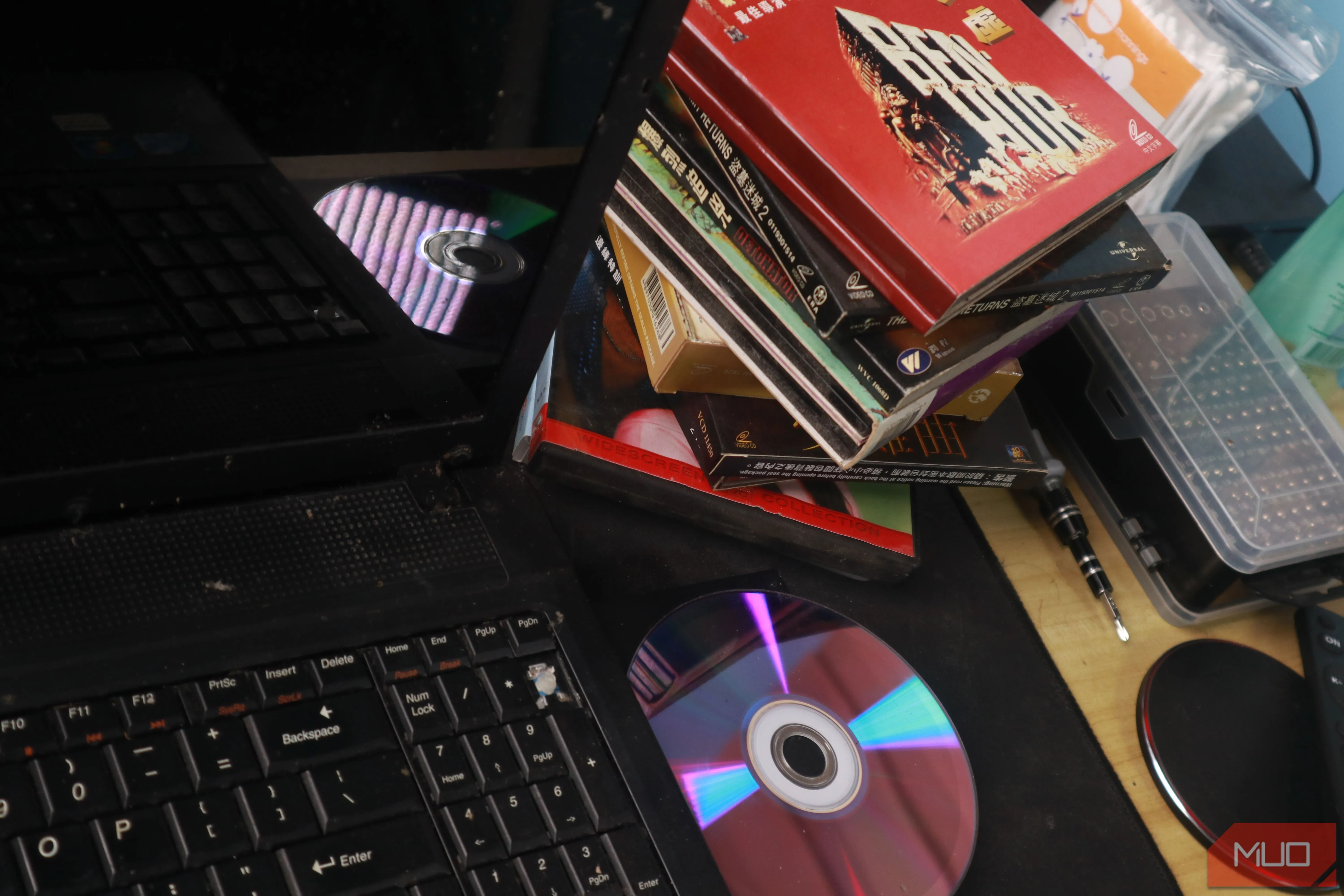 Laptop cũ đang trích xuất dữ liệu từ đĩa CD, minh họa việc số hóa nội dung giải trí