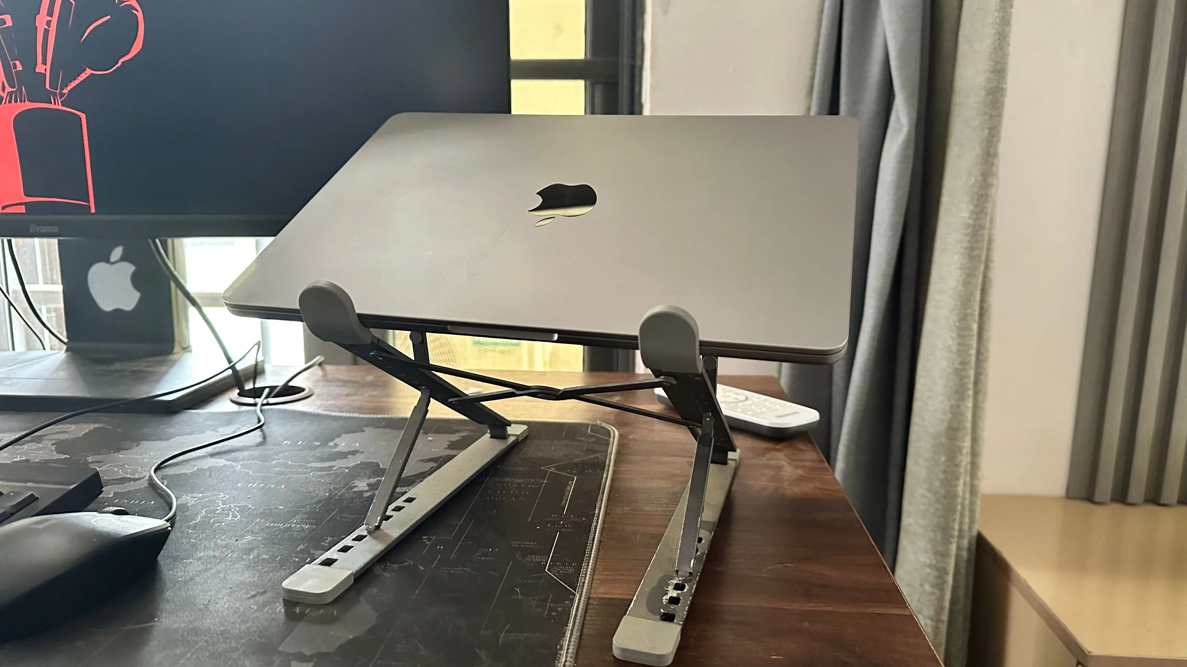 MacBook đặt trên giá đỡ bên cạnh màn hình rời, minh họa cách tối ưu tản nhiệt khi sử dụng màn hình phụ