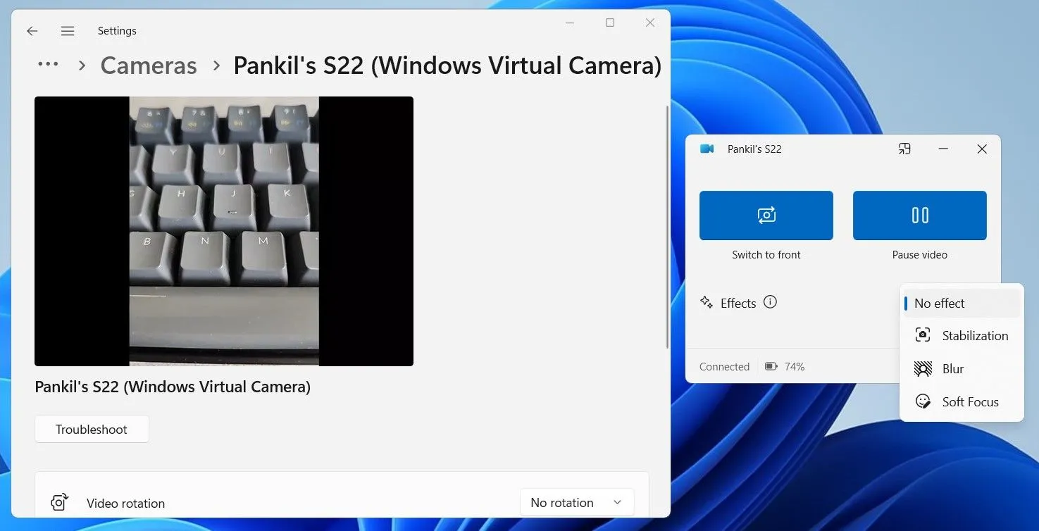 Màn hình máy tính chạy Windows 11 hiển thị cuộc gọi video, với điện thoại Android được kết nối để sử dụng làm webcam thông qua ứng dụng Phone Link.