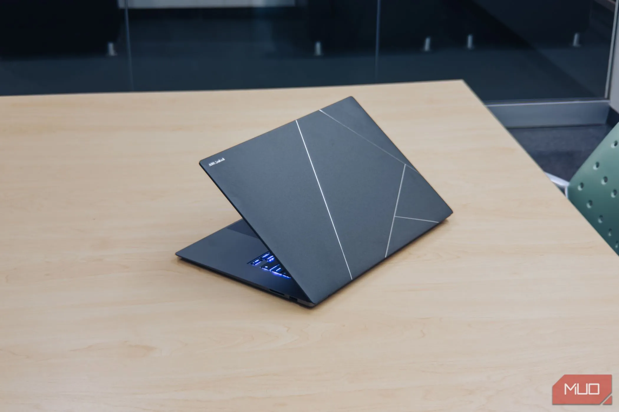 Mặt lưng laptop ASUS Zenbook S 16 OLED màu trắng trên bàn gỗ