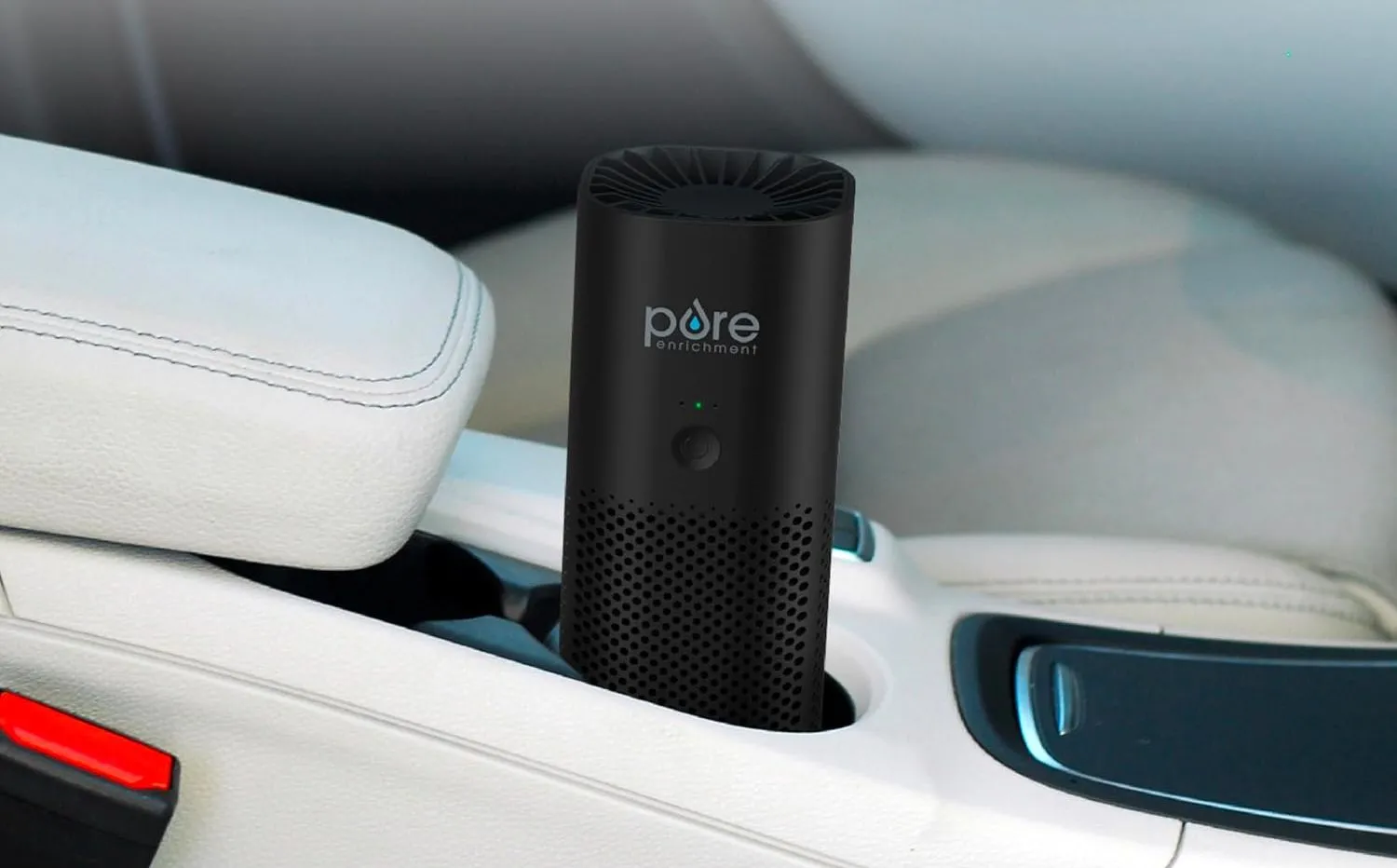 Máy lọc không khí di động PureZone Mini của Pure Enrichment đặt trong khay đựng cốc xe hơi.