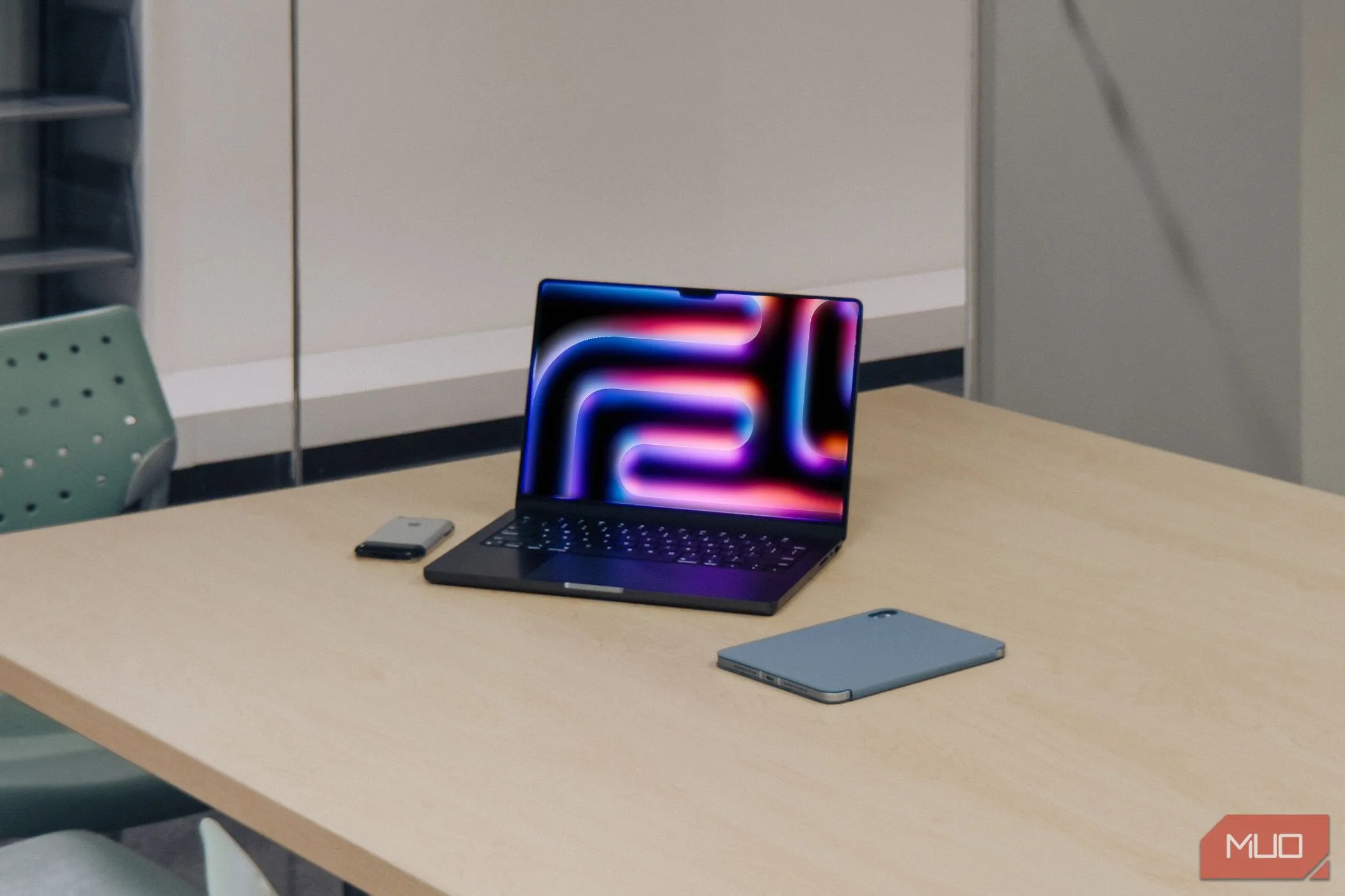 Máy tính xách tay MacBook Pro M4 cạnh iPad và iPhone 2G đời đầu trên bàn