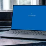 Máy tính xách tay Windows 11 đang cập nhật hệ thống, hiển thị thông báo "Please wait" trên màn hình, tiềm ẩn lỗi sau khi cài đặt
