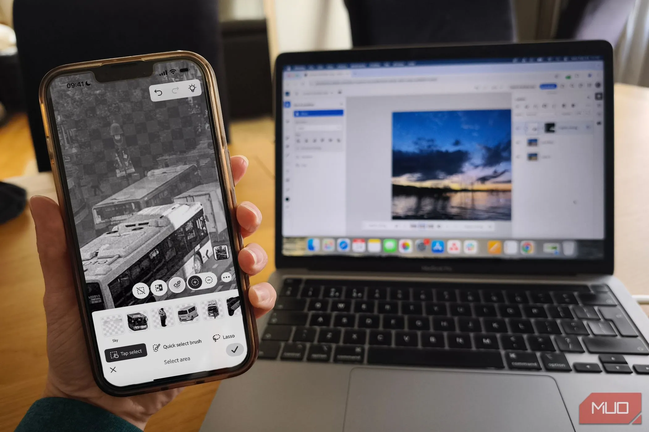 Minh họa ứng dụng Photoshop Mobile trên điện thoại và Photoshop trên Web hiển thị trên MacBook, thể hiện tính linh hoạt của gói đăng ký.