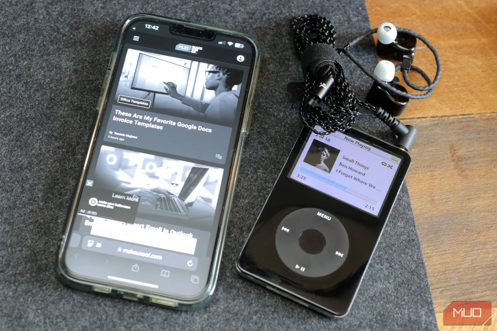 Một chiếc iPod màu đen và iPhone 13 màu xám đang đặt trên tấm lót bàn bằng nỉ