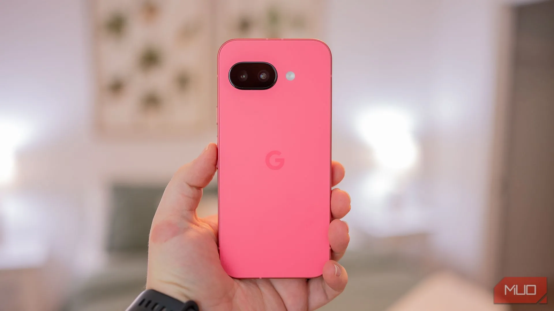 Một người đang cầm Google Pixel 9a, hiển thị mặt lưng của điện thoại với thiết kế mới