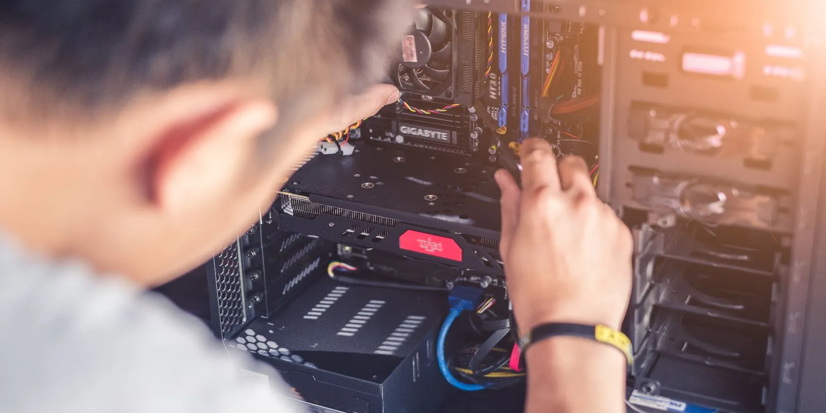 Một người đang dùng tuốc nơ vít bên trong thùng máy tính để bàn (PC), cho thấy sự dễ dàng trong việc sửa chữa và thay thế linh kiện
