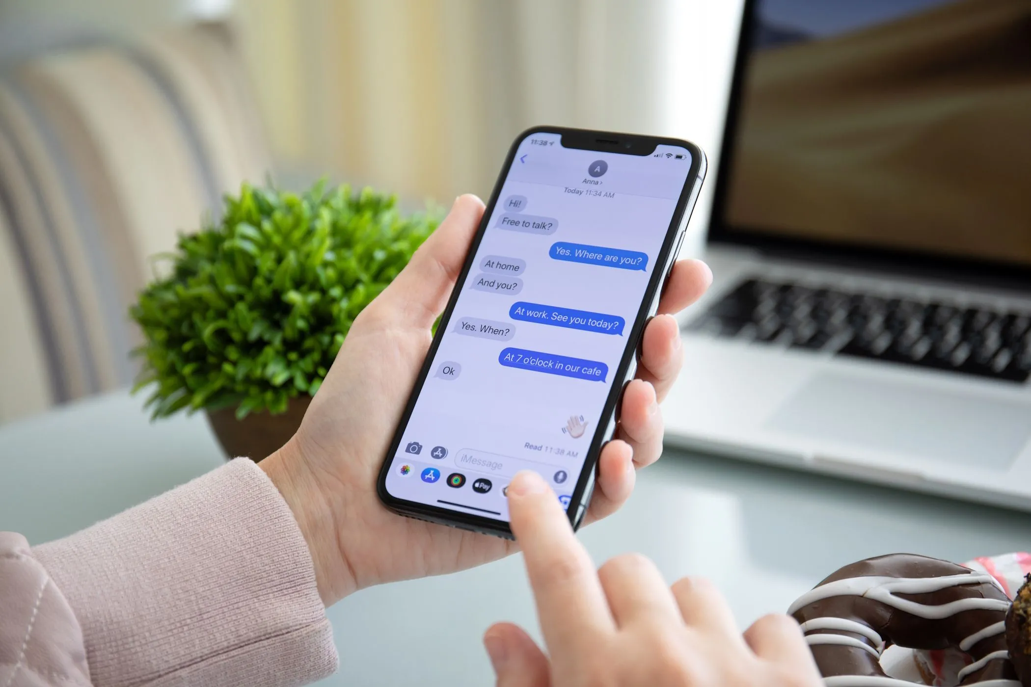 Một phụ nữ đang sử dụng ứng dụng iMessage trên iPhone của mình, thể hiện trải nghiệm nhắn tin đặc trưng của hệ sinh thái Apple