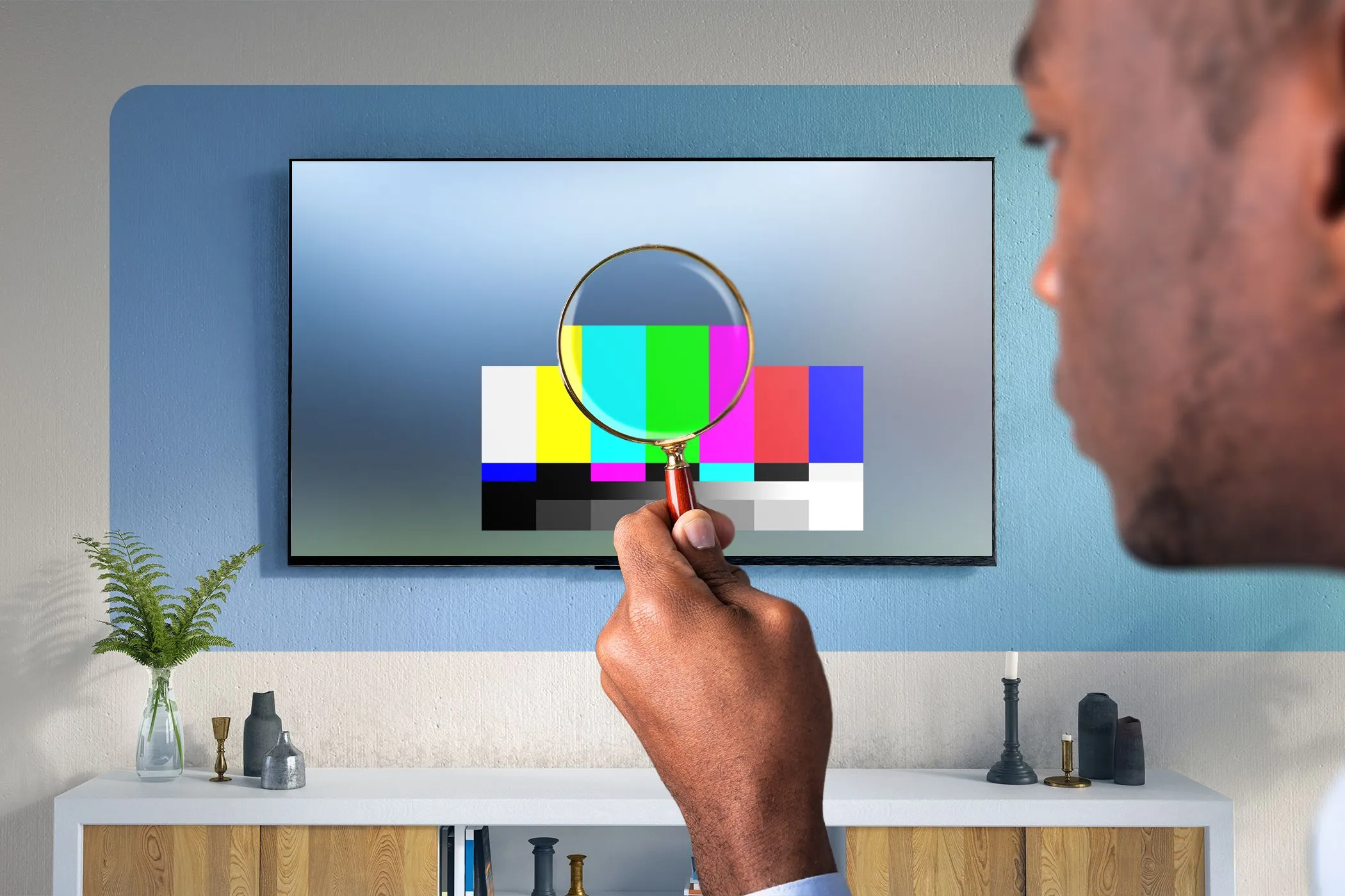 Người đàn ông dùng kính lúp kiểm tra chất lượng hiển thị của TV, minh họa sự cần thiết của việc đánh giá chi tiết dải màu HDR