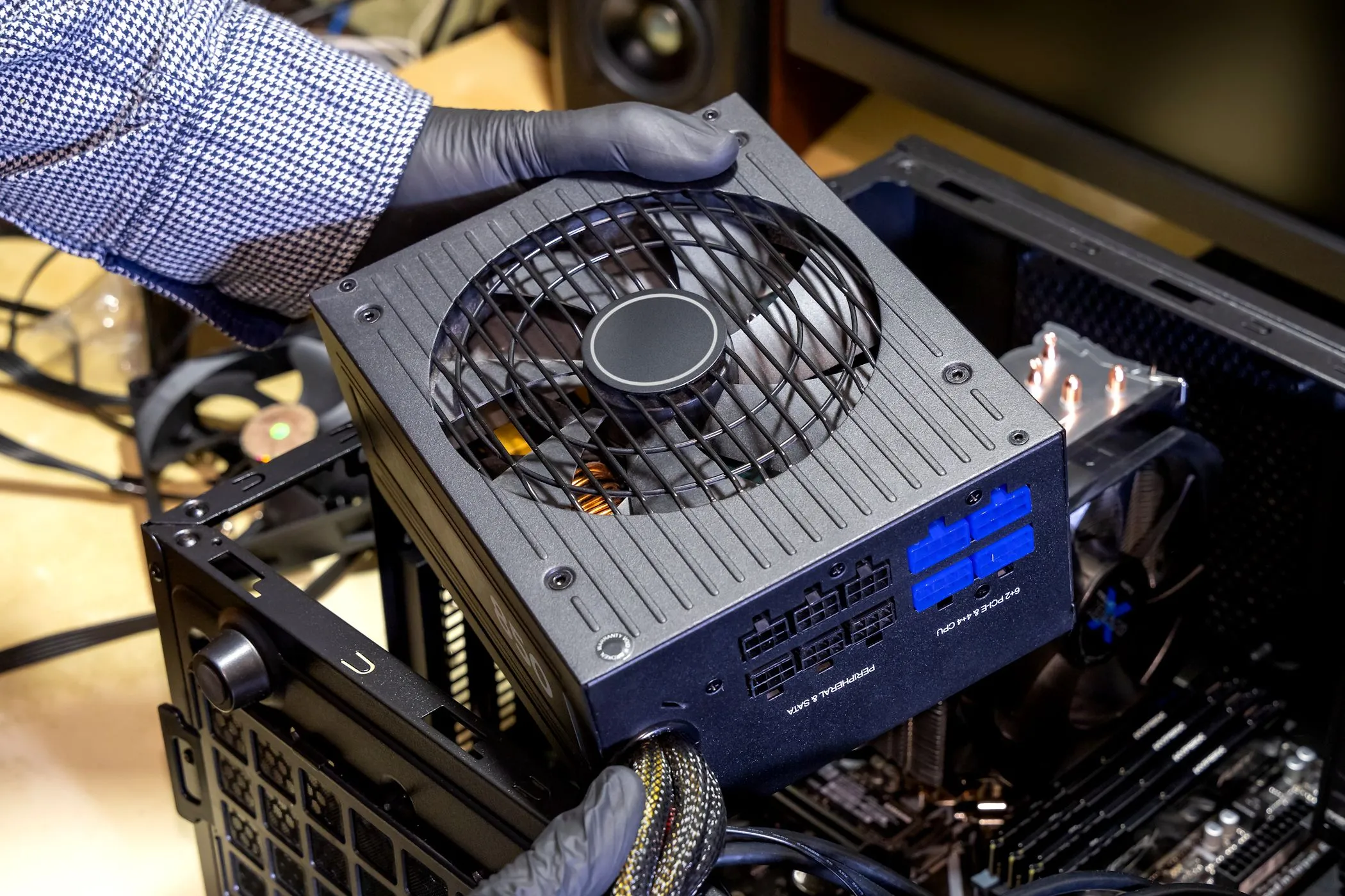 Người đang lắp bộ nguồn (PSU) vào vỏ máy tính