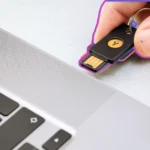 Người dùng cắm khóa bảo mật vật lý Yubico vào cổng USB của laptop để khóa máy tính