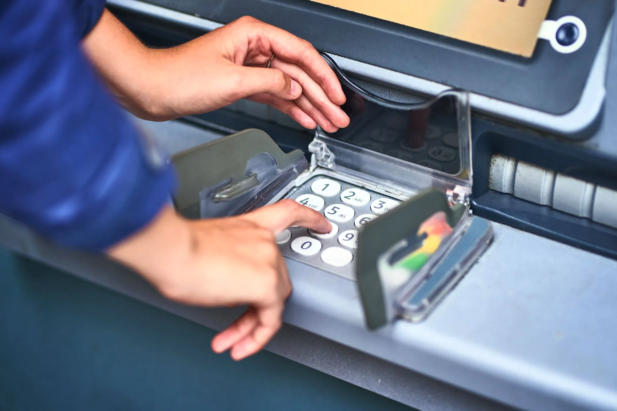 Người dùng che tay khi nhập mã PIN tại cây ATM để phòng chống camera quay lén