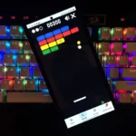 Người dùng chơi game Block Breaker trên điện thoại di động với thanh đỡ được điều khiển bằng ngón tay