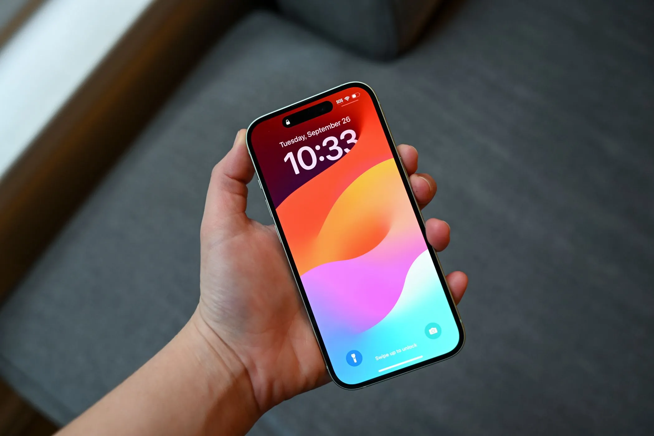 Người dùng đang cầm chiếc iPhone 15, cho thấy màn hình hiển thị mượt mà sau khi dán tấm bảo vệ che vết xước