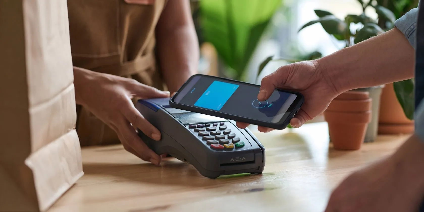 Người dùng sử dụng điện thoại để thanh toán không tiếp xúc bằng NFC tại quầy thu ngân trong siêu thị.