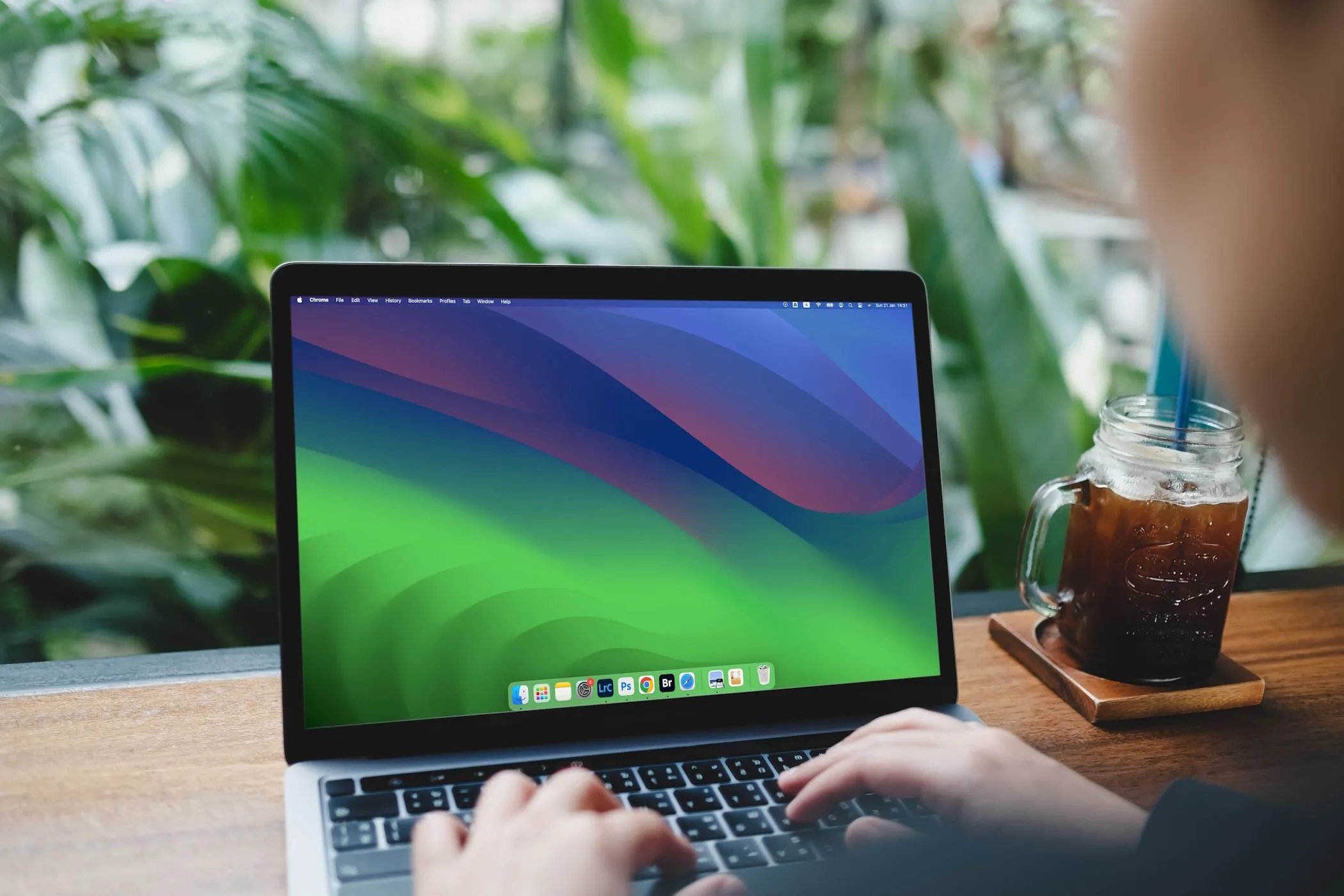 Người phụ nữ đang gõ phím trên MacBook Air, thể hiện hành động nghiên cứu thông tin chi tiết về một công ty hoặc dự án trực tuyến để xác minh tính hợp pháp.
