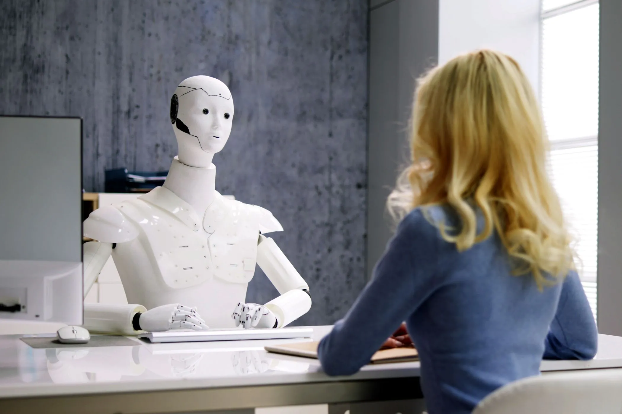 Người phụ nữ phỏng vấn với robot AI, minh họa tương tác giữa con người và AI agent tự hành trong công việc.