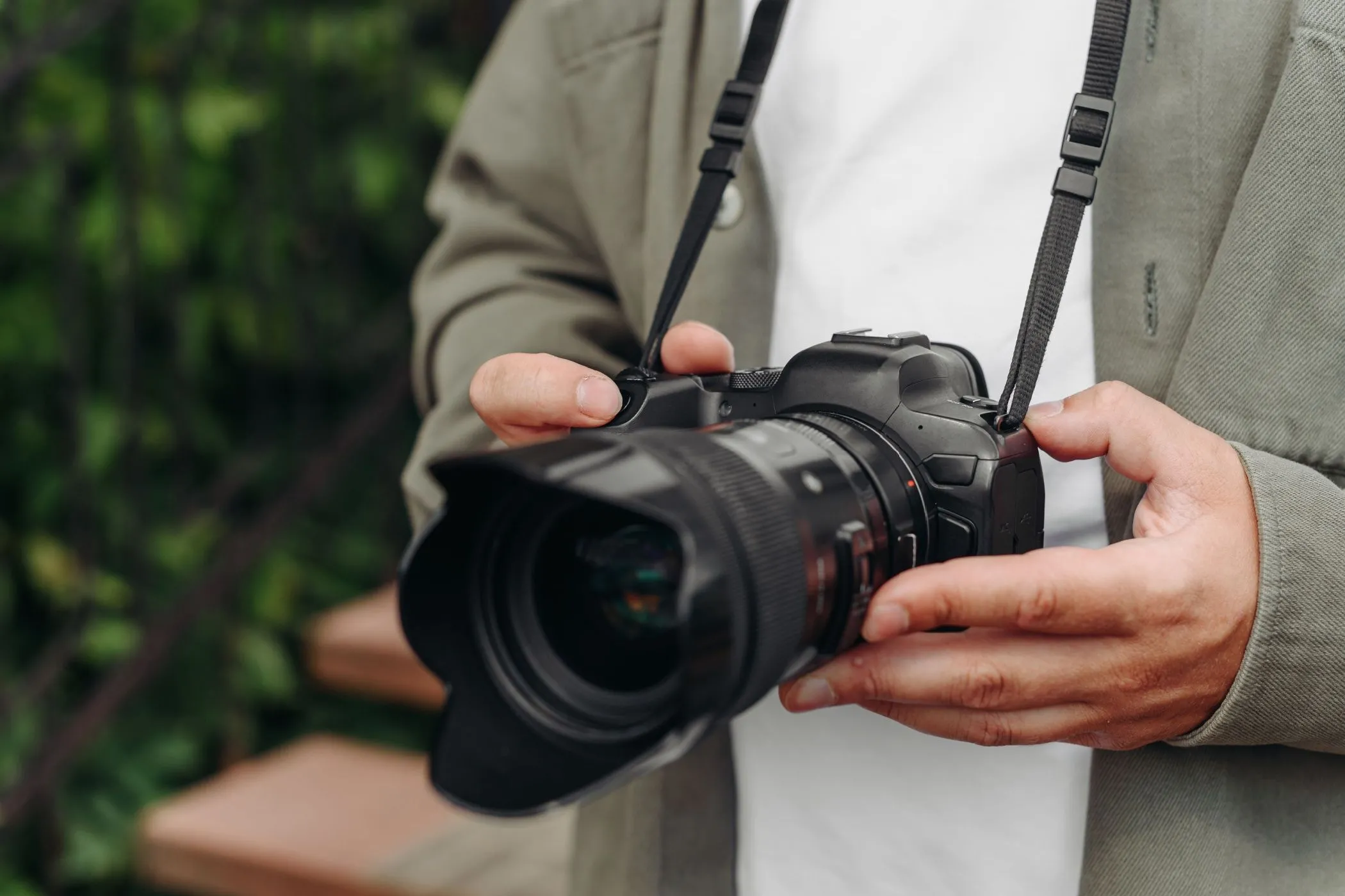 Nhiếp ảnh gia trẻ tuổi đang cầm máy ảnh DSLR, thể hiện sự chắc chắn và độ bền của thiết bị