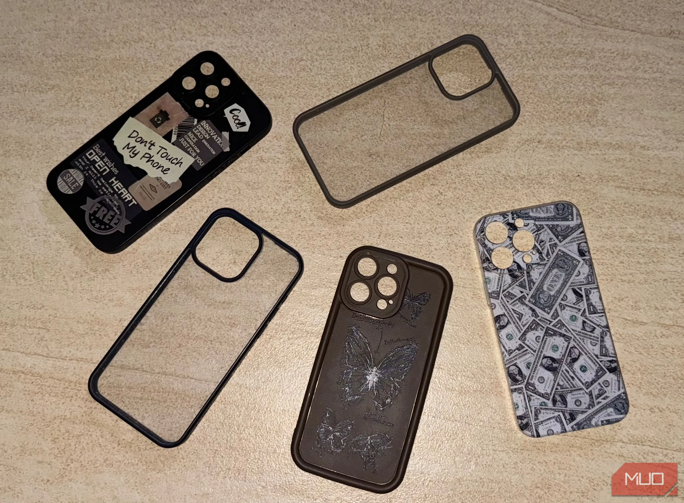 Nhiều ốp lưng điện thoại iPhone 15 Pro Max trên sàn, cho thấy sự đa dạng và độ dày mà chúng có thể thêm vào thiết bị.