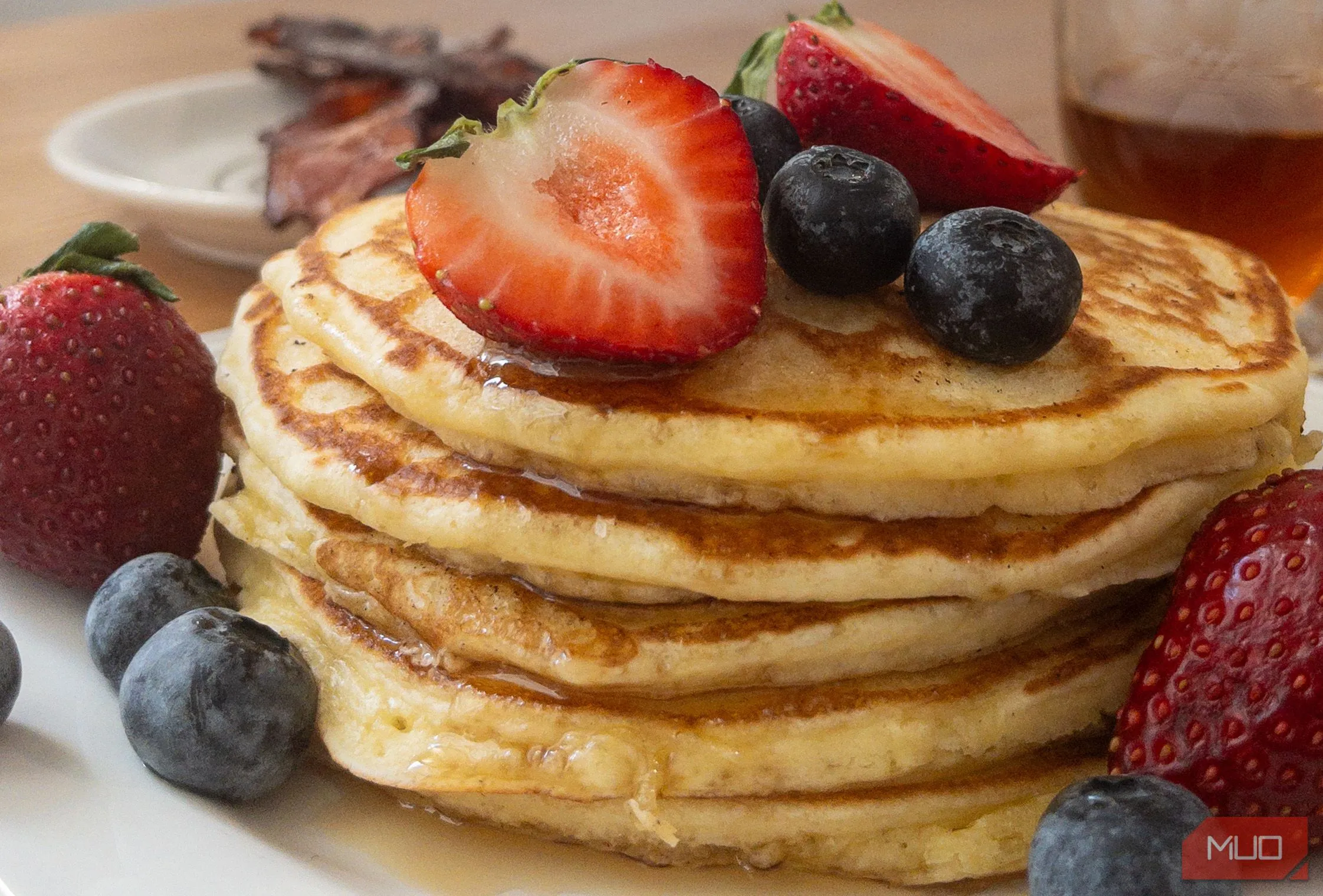 Những chiếc bánh pancake xếp chồng được chụp từ góc thấp, làm nổi bật sự phong phú và lớp phủ